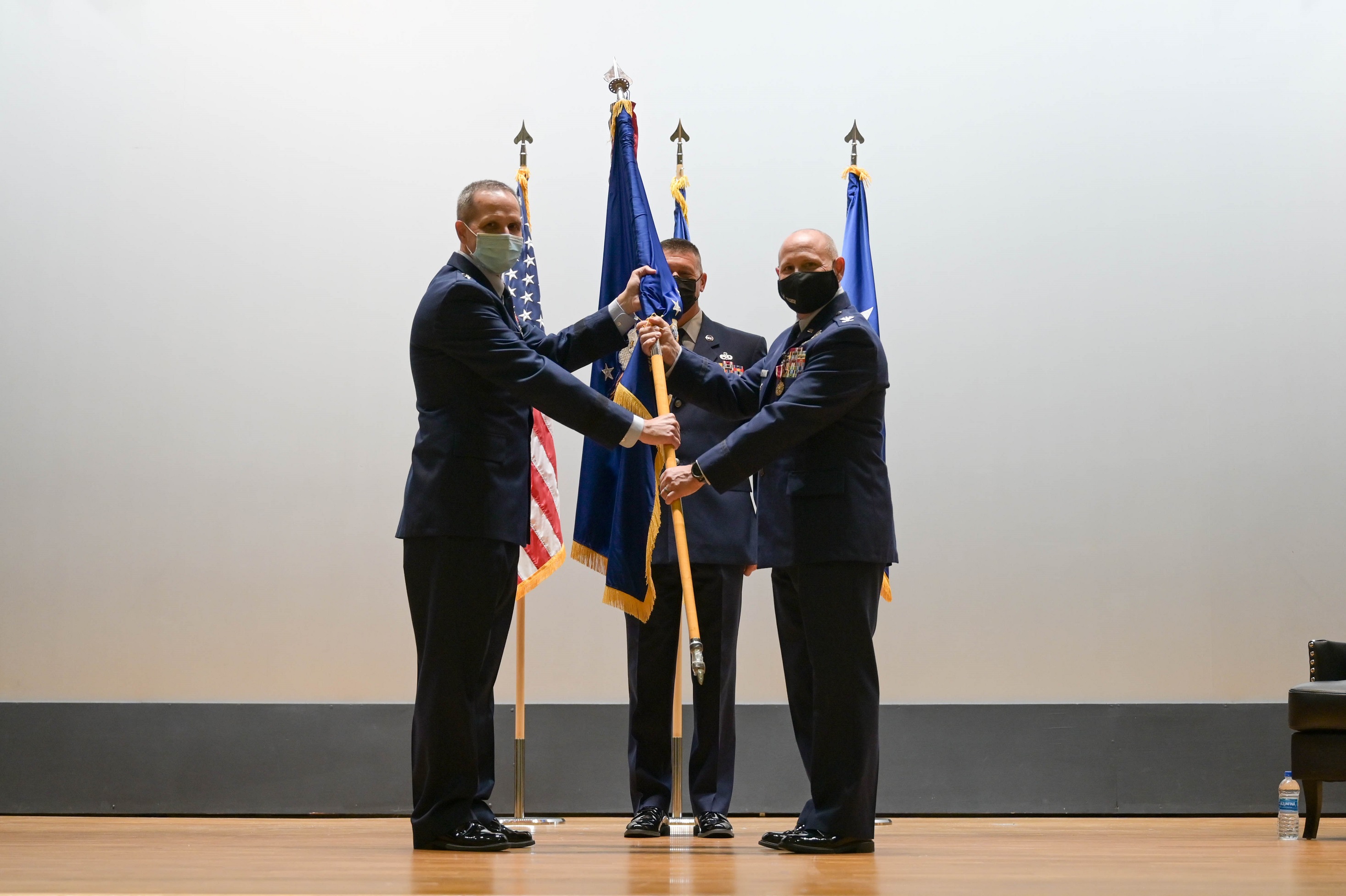 Maj. General Jeffrey T. Pennington, 4th Air Force commander, passes the guidon to Col. Kurt A. Matthews as he takes command of the 927th Air Refueling Wing during a ceremony Sept. 11, 2021 in the base theater at MacDill Air Force Base, Florida. 